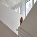 Young woman at sairs with glass at  Leiden University College The Hague