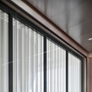 Fire resistant glass wall with extra glass partition for sound reduction.