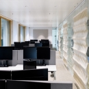 Multiple workstations in a room separated by glass.
