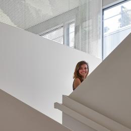 Young woman at sairs with glass at  Leiden University College The Hague