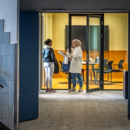 Hallway with glass partitions and door at the end