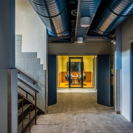 Hallway with glass partitions and door at the end