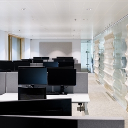 Multiple workstations in a room separated by glass.