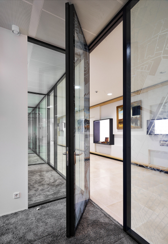 Glazensysteemwand met flush kaderdeur uitgevoerd in zwarte profielen