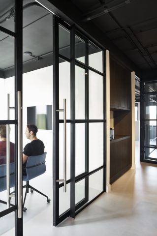 Sliding door in a industrial look glass wall