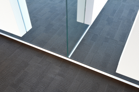 T-connection of single glass office walls with on each wall a acoustic panel