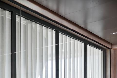 Fire resistant glass wall with extra glass partition for sound reduction.
