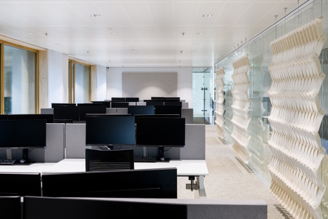 Multiple workstations in a room separated by glass.