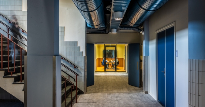Hallway with glass partitions and door at the end